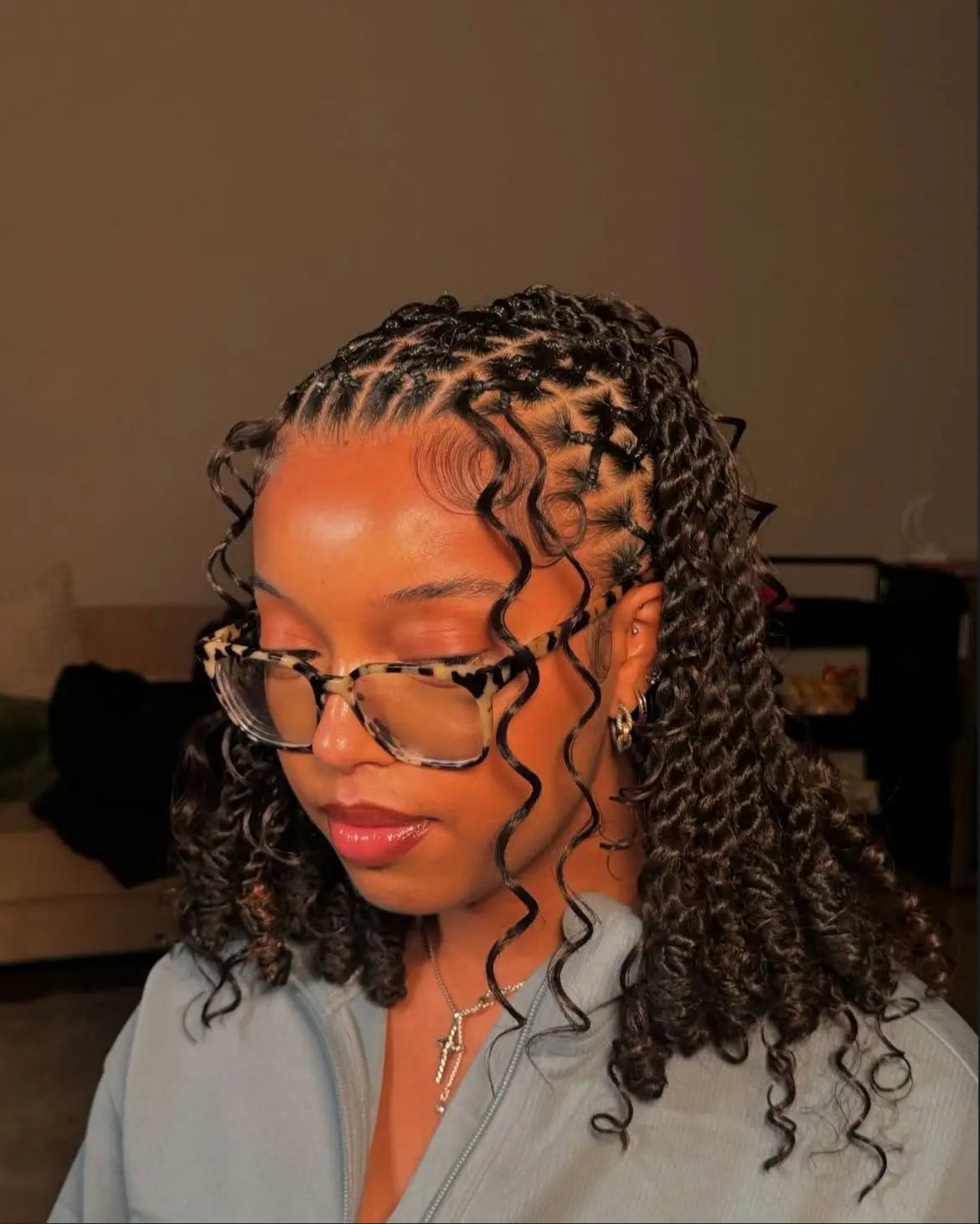 Look curly noir avec détail de tresses